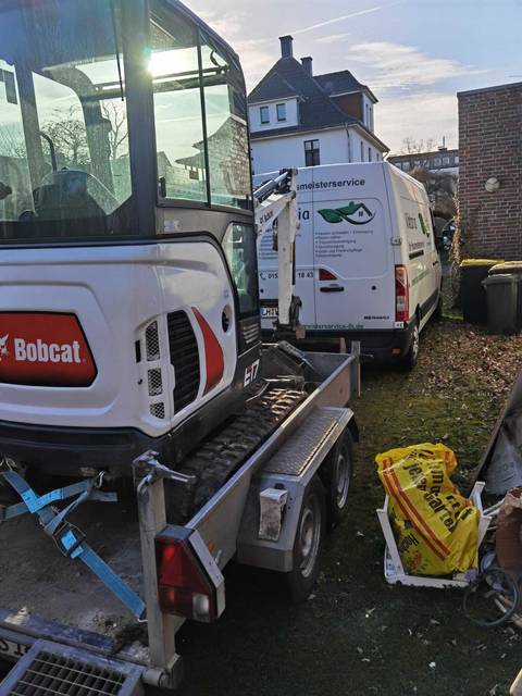Minibagger und Firmenfahrzeug im Einsatz